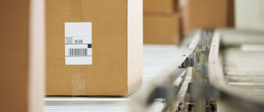 Shipping boxes on conveyor belt in warehouse