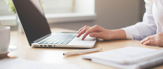 Woman checking project status on laptop