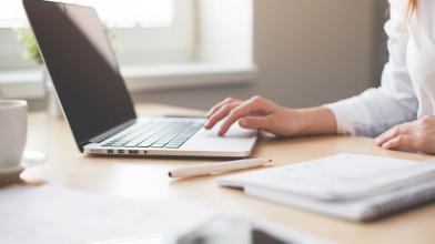 Woman checking project status on laptop